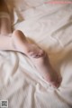 A close up of a person's feet on a bed.