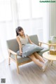 A woman sitting on a couch with a pillow on it.