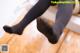 A pair of black tights sitting on top of a wooden floor.