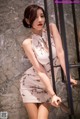 A woman in a short dress leaning against a railing.