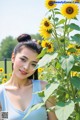 A woman standing in front of a field of sunflowers.