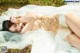 A woman laying on the ground in a white dress.