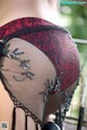 A close up of a woman wearing a red and black lingerie.