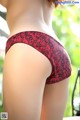 A woman wearing a red and black lace panties.