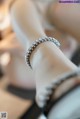 A close up of a woman's foot wearing a diamond bracelet.