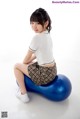 A woman sitting on top of a blue ball.