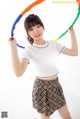 A young woman holding a hula hoop in her hands.