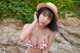 A woman in a bikini and a straw hat posing for a picture.