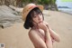 A woman in a straw hat on a beach.