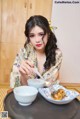 A woman sitting at a table with a plate of food.