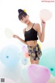 A woman standing in front of a bunch of balloons.