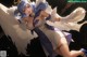 Anime girl with blue hair and white wings posing for a picture.