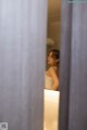 A woman standing in front of a mirror in a bathroom.