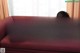 A woman in a red bikini laying on a red couch.
