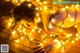 A naked woman laying on a wooden floor covered in lights.