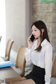 A woman sitting at a table talking on a cell phone.