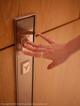 A woman's hand is pressing a button on a door.