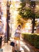 A woman in a school uniform is walking down the street.