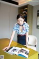 A woman standing at a table with a book on it.