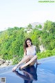 A woman sitting on the edge of a swimming pool.