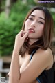 A woman in a black tank top posing for a picture.