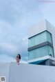 A woman standing on top of a white building.