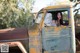 A woman sitting in the driver's seat of an old truck.