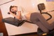 A woman laying on a stationary bike in a gym.