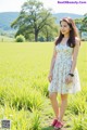 A woman standing in a field of green grass.